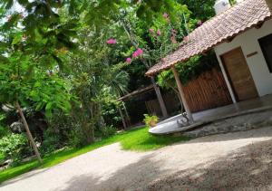 uma casa com um banco ao lado de um jardim em Estancia Lapislázuli em Bacalar