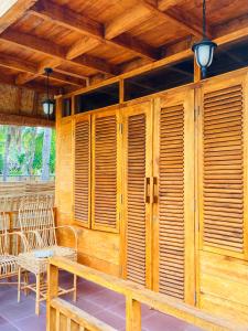 - une terrasse couverte avec volets en bois, table et chaises dans l'établissement SAJA Cottage, Gili Meno, à Gili Meno