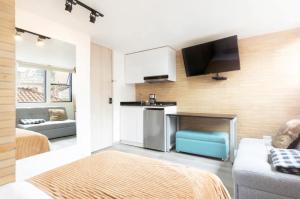 mała kuchnia i salon z kanapą i telewizorem w obiekcie A Moderno loft con wifi en Centro de Bogotá w mieście Bogota