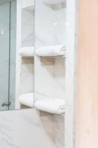 W łazience znajdują się białe ręczniki i lustro. w obiekcie A Moderno loft con wifi en Centro de Bogotá w mieście Bogota