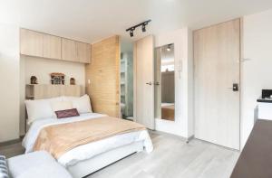 sypialnia z dużym białym łóżkiem w pokoju w obiekcie A Moderno loft con wifi en Centro de Bogotá w mieście Bogota
