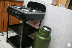 una estufa negra en una cocina con un cubo de basura en Denverwing Homes. en Eldoret