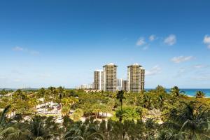 パーム・ビーチ・ショアーズにあるPalm Beach Marriott Singer Island Beach Resort & Spaのヤシの木と海の景色を望むリゾートです。