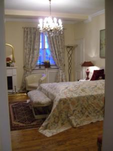 a bedroom with a bed and a chair and a chandelier at Bastgen Bed & Breakfast in Wittlich