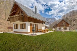 una casa en las montañas con un gran patio en Riverside Resort Stari Malni Kolpa - Happy Rentals, en Osilnica