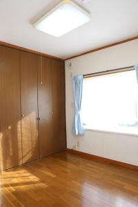 an empty room with a large window and wooden cabinets at コテージ　マリーゴールド in Nasu-yumoto