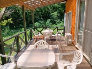 a deck with white chairs and tables and a heater at コテージ　マリーゴールド in Nasu-yumoto