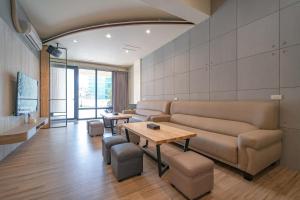 a living room with a couch and a table at 安平-宅17包棟 KTV 民宿 x 户外烤肉區-依人數開放房型 in Tainan