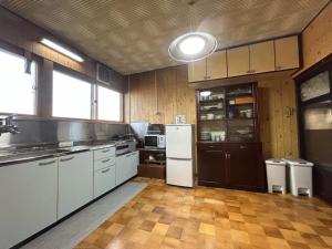 uma grande cozinha com electrodomésticos brancos e armários de madeira em Hakuigun - House - Vacation STAY 14651 