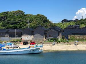 ein Boot im Wasser vor den Häusern in der Unterkunft Hakuigun - House - Vacation STAY 14651 