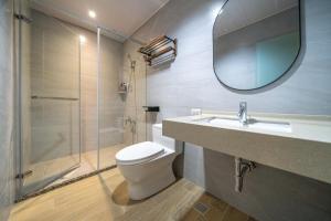a bathroom with a toilet and a sink and a mirror at 安平-宅17包棟 KTV 民宿 x 户外烤肉區-依人數開放房型 in Tainan +20 photos