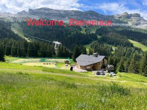 a house on a hill with a welcome sign on it at Hôtel LAPIAZ & Spa - FLAINE in Flaine