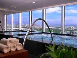 a bathroom with a tub with a view of the city at Windsor Hotel Taichung in Taichung +21 photos