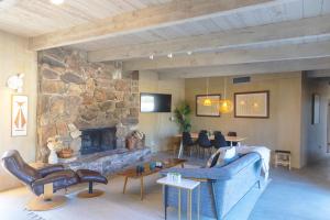 a living room with a couch and a stone fireplace at Designer Hideaway in Borrego Springs