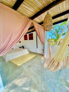 a bedroom with a bed and a hammock at El Eden Escondido in Puerto Escondido