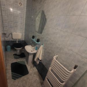 een badkamer met een wastafel, een toilet en een spiegel bij BabciaHouse in Augustów