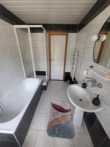 een badkamer met een bad, een wastafel en een bad bij BabciaHouse in Augustów