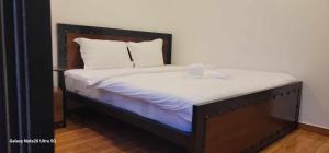 a bed with white sheets and two boxes on it at Park Inn Boutique and Hostel in Kampot
