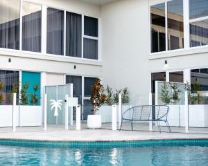 a pool with a chair next to a building at Peninsula Hotel Motel in Adelaide