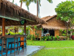 eine Bar vor einem Resort mit Strohdach in der Unterkunft Margarita Beach in Khanom