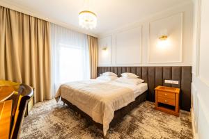 een slaapkamer met een bed, een tafel en een raam bij Hotel Piast in Opole