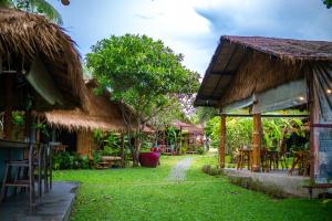 ein Resort mit Tischen und Stühlen im Gras in der Unterkunft Margarita Beach in Khanom + 37 Fotos