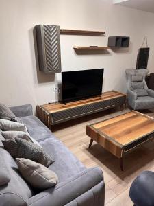 een woonkamer met een bank en een flatscreen-tv bij شقه فندقيه فاخره in Güngören