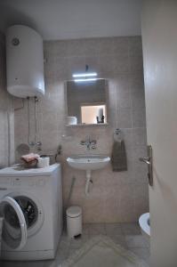 een badkamer met een wasmachine en een wastafel bij Charming studio near downtown in Belgrado