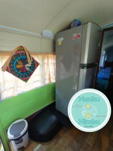 a small kitchen with a refrigerator and a window at Nanku Nimbu Casa-Bus equipada cerca de playas in Sámara