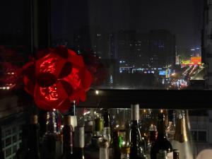 una ventana con botellas de vino y una flor roja en Sifang Space Hostel Xi'an - Xi'an TIYUCHANG metro station Line2 en Xi'an