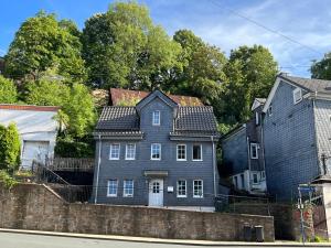 a large gray house sitting on the side of a street at Mehrere Zimmer in erster Lage in Siegen