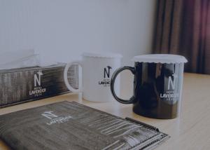 a table with two coffee mugs and a book at Jeju Lavender Hotel in Seogwipo