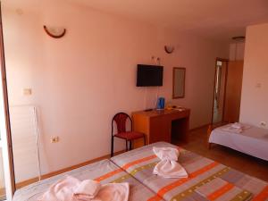 um pequeno quarto com uma cama e uma cadeira em Tony Guest House em Sozopol