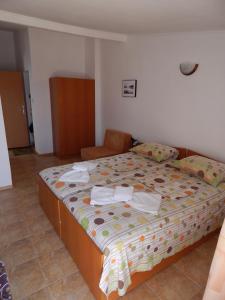 a bedroom with a large bed with towels on it at Tony Guest House in Sozopol