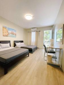 1 dormitorio con 2 camas, mesa y escritorio en Ana’s Haven in Ohio St. en Olongapo