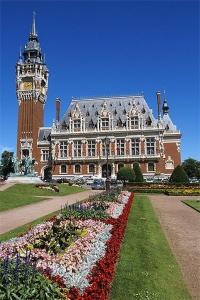 un gran edificio con una torre de reloj delante de él en Pasithéa Loft Spa Privatif, en Calais