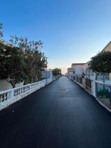 una strada vuota con un ponte, alberi e case di Apartment Mona Vir a Vir (Puntadura)