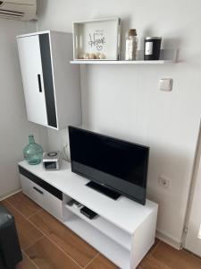 un soggiorno con TV su un centro di intrattenimento bianco di Apartment Mona Vir a Vir (Puntadura)