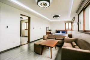 a living room with a couch and a bed at The Seri Resort in Seogwipo