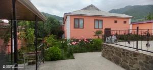 a pink house with a garden in front of it at Gabala Mountains Villa in Gabala