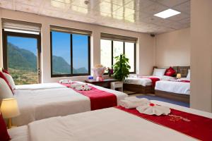 um quarto com 3 camas com lençóis vermelhos e brancos em En Hotel Sapa em Sapa