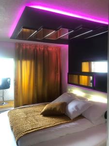 um quarto com uma cama com iluminação roxa em LovRoz em Perros-Guirec