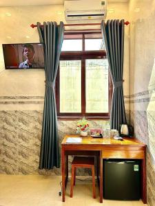 um quarto com uma televisão e uma mesa com uma televisão em Khách sạn Vĩnh Chương em Soc Trang