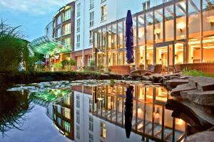 um edifício com o seu reflexo numa massa de água em Courtyard by Marriott Dresden em Dresden