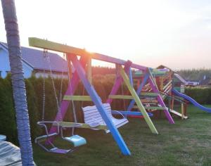 a playground with a slide in a yard at Domki Klif Rusinowo in Rusinowo