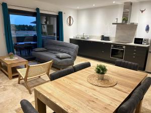 uma sala de estar com uma mesa de jantar e uma cozinha em Gîte à la ferme avec Piscine & Spa em Arles