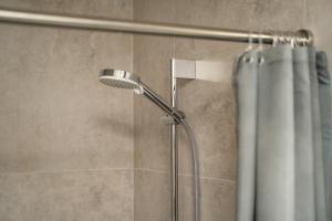 W łazience znajduje się prysznic z zasłoną prysznicową. w obiekcie Nordic Studio 139 In Prime Vilnius Location w Wilnie +27 zdjęć