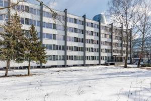 un immeuble de bureaux avec de la neige devant lui dans l'établissement Nordic Studio 139 In Prime Vilnius Location, à Vilnius