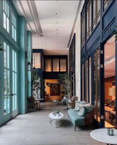 a living room with a green couch and chairs at Kanvaz Village Resort Seminyak in Seminyak