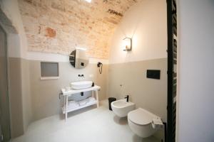 a bathroom with a white toilet and a sink at San Marco Boutique Rooms in Alberobello